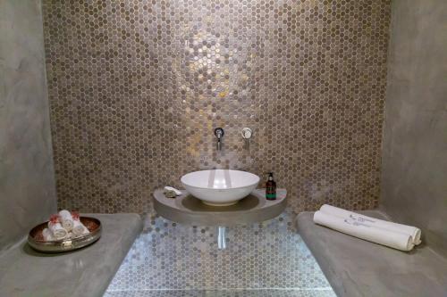 a bathroom with a sink in a wall at Messinian Icon Hotel & Suites in Kalamata
