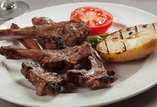 a plate of food with meat and a tomato at Hotel Restaurant Les Brases in Sort