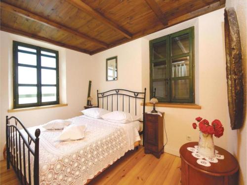 a bedroom with a bed with white sheets and a window at Holiday House Brela in Brela