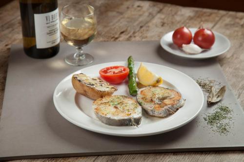 a plate of food with bread and tomatoes and a bottle of wine at Hotel Restaurant Les Brases in Sort