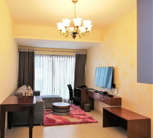 a living room with a couch and a tv at Coventina Lake Suites in Dhaka