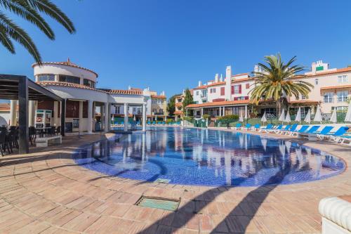 una gran piscina con palmeras y edificios en Old Village & Prestige, en Vilamoura