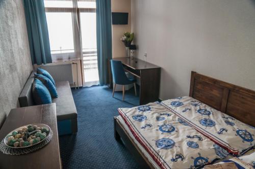 a bedroom with a bed and a desk and a table at Penzión Anima in Kaluža