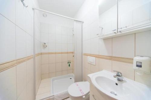 Baño blanco con aseo y lavamanos en Hotel Piramida en Podgorica
