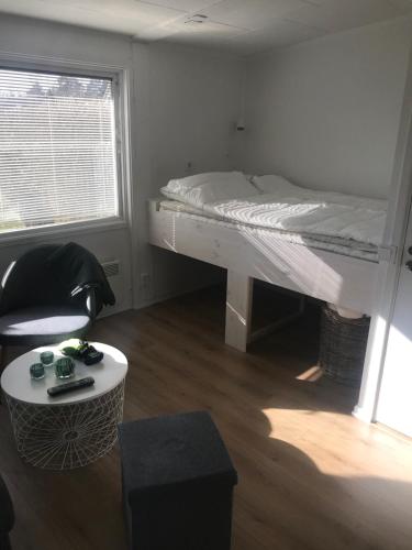 a bedroom with a bed and a chair and a table at Lägenhet Smågårde Tofta in Tofta