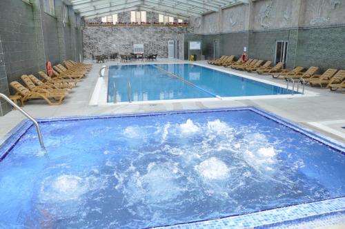 a large swimming pool with chairs in a building at Eser Diamond Hotel Spa & Convention Center İstanbul in Silivri