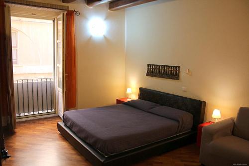 a bedroom with a bed and a couch and a window at Casa Vacanza Pablo Castello in Cagliari