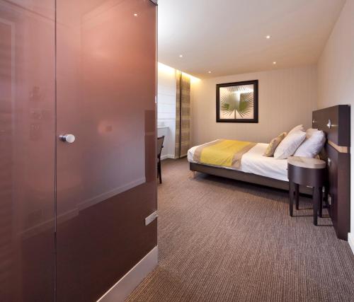 a hotel room with a bed and a sliding door at Logis Hotel Restaurant Muller in Niederbronn-les-Bains