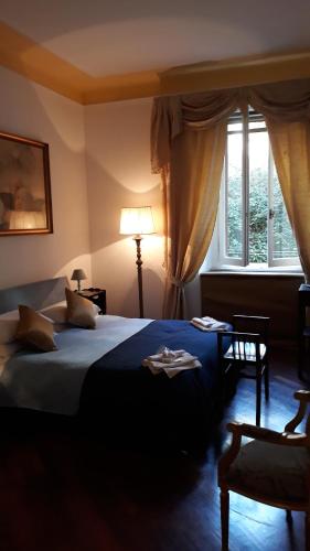 a bedroom with a bed and a lamp and a window at Florian in La Spezia