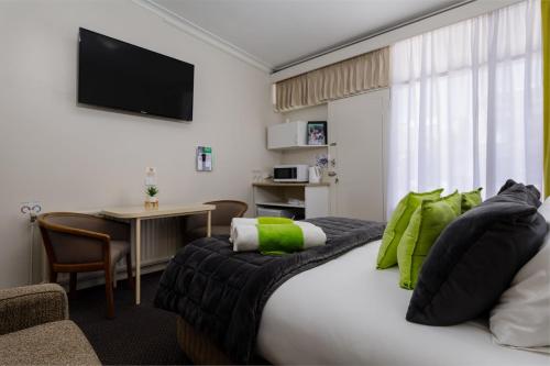 a hotel room with a large bed and a table at Bendigo Oval Motel in Bendigo