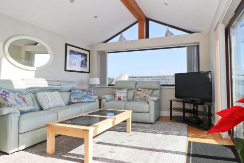 a living room with a couch and a tv at Sea View House in Newquay