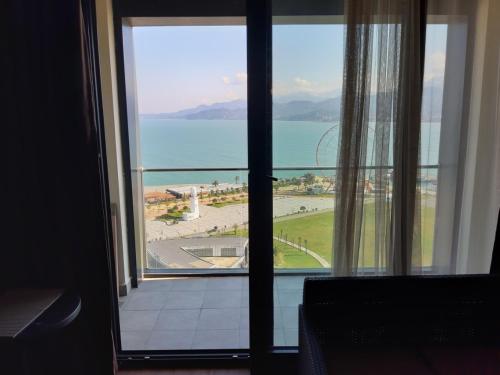 a view of the ocean from a room with a window at Premium apartment in Porta Batumi Tower in Batumi