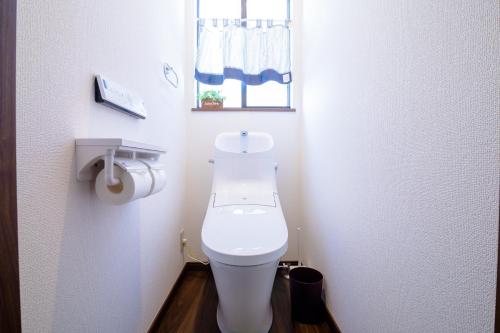 a small bathroom with a toilet and a window at SAKURA FUJI in Fujikawaguchiko