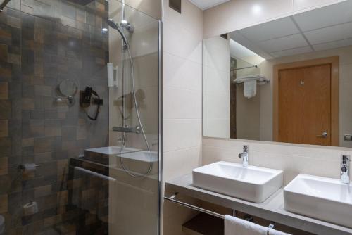 a bathroom with two sinks and a shower at Hotel Real in Lleida