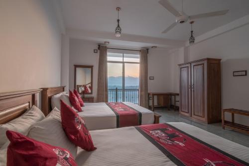 um quarto de hotel com duas camas e uma varanda em Beauty Hills em Kandy