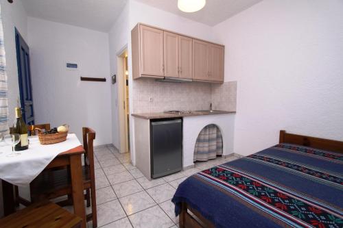 a room with a kitchen and a table and a bed at Olympic Villas in Oia