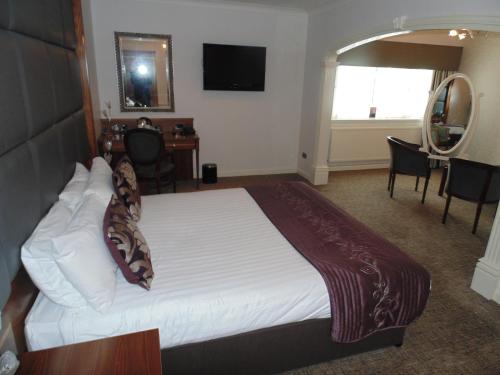 a bedroom with a large white bed in a room at Best Western Plus Lancashire Manor Hotel in Skelmersdale