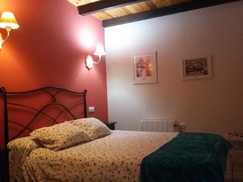 una camera con un letto in una stanza con pareti rosse di Casita de Folgosa a Ribadeo