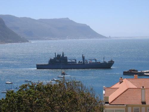 a large ship in a large body of water at A Boat House in Simonʼs Town