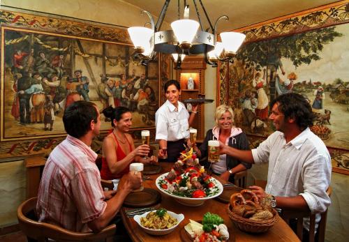 a group of people sitting around a table with food at Villa Knobelsdorff in Pasewalk