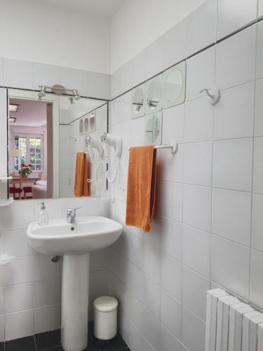 a white bathroom with a sink and a mirror at La Merella in Rapallo