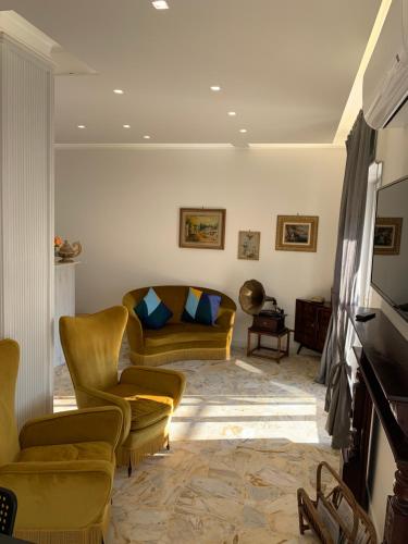 - un salon avec des fauteuils jaunes et un canapé dans l'établissement Di Palma Suite Museum, à Naples