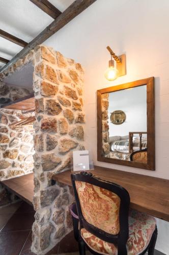 a mirror in a room with a stone wall at Limeri Traditional Guest House in Monólithos