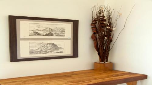 a vase on a table next to a wall with a picture at Fοivos and Athina Villas in Archanes