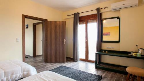 a bedroom with a bed and a desk and a mirror at Fοivos and Athina Villas in Archanes