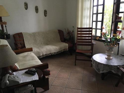uma sala de estar com um sofá e uma mesa em Schulz Pousada em Joinville