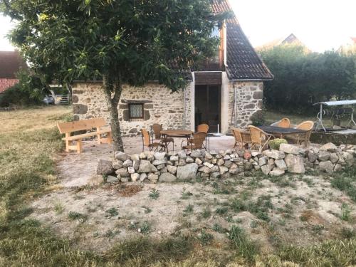 una casa de piedra con una mesa y sillas delante de ella en Charming holiday home overlooking the valley, en Lapeyrouse