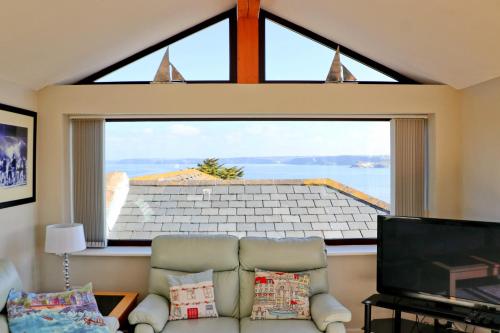 a living room with a couch and a large window at Sea View House in Newquay