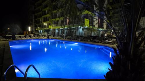 a large blue swimming pool at night at Alezzi Beach Resort in Mamaia Nord
