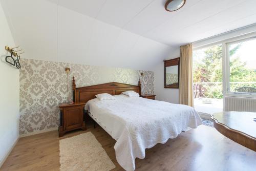 um quarto com uma cama e uma grande janela em Bed and Breakfast Hoorn em Hoorn