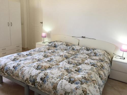 1 cama grande en un dormitorio con 2 lámparas en Il Ginepro, en Valledoria