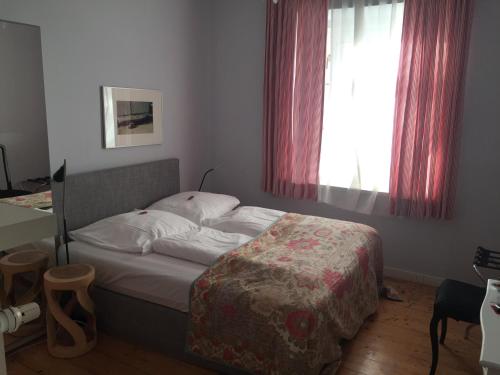 a small bedroom with a bed with a window at das HOTEL in München in Munich