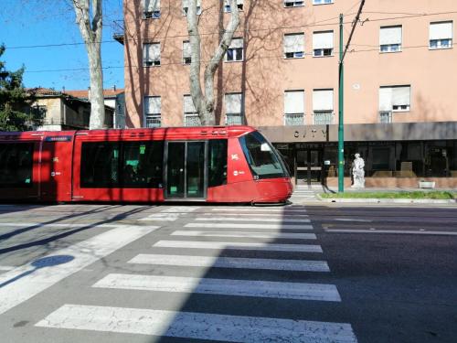 a red train is on a city street at City of Art Venice LLoyd in Marghera