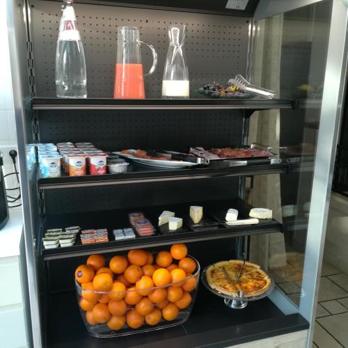 a refrigerator filled with oranges and other food at Hotel Jean Moët in Épernay