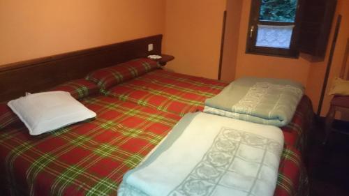 Zardón的住宿－El Cantiellu，一张床上有两个枕头的房间