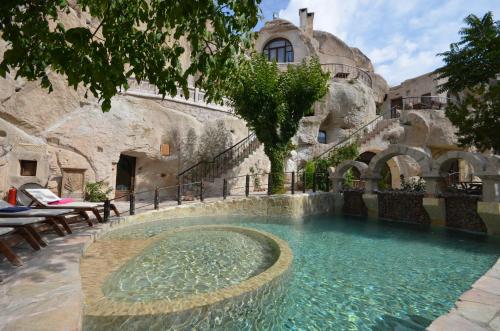 a large swimming pool in a stone building at Cappadocia Gamirasu Cave Hotel in Ayvalı