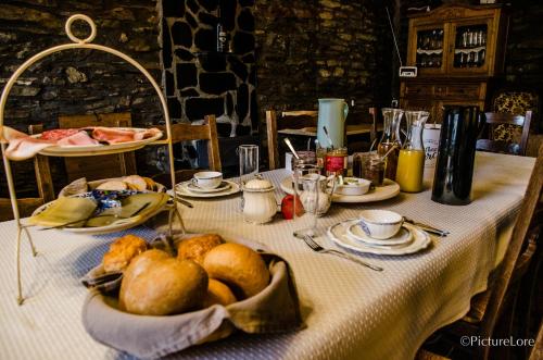 a table with a white table cloth with bread on it at B&B Au Canard in La Roche-en-Ardenne
