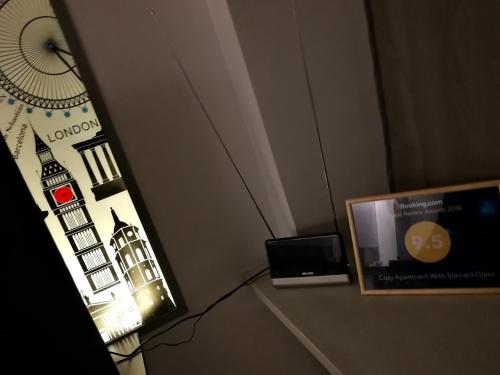 a picture of a clock and a television in a room at Vilnius apartment with stained glass in Vilnius