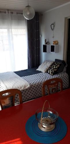 um quarto com uma cama e uma tigela sobre uma mesa em cosy logement à la campagne em Marthille