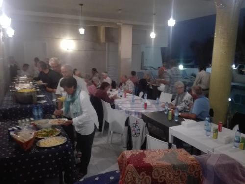 a group of people sitting at tables eating food at Salalah Beach Villas in Salalah