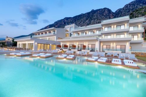 a hotel with a swimming pool with lounge chairs at Messinian Icon Hotel & Suites in Kalamata