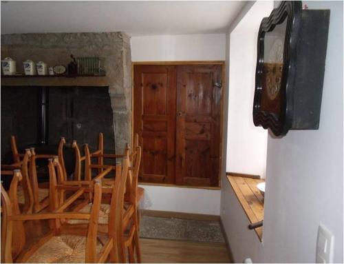 d'une salle à manger avec une table, des chaises et un réfrigérateur. dans l'établissement Aubrac, maison de vacances, à Malbouzon