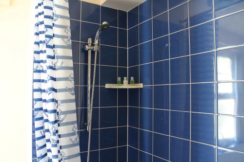 ペイントンにあるNumber 6 Braeside Mewsの青いタイル張りのバスルーム(シャワー、シャワーカーテン付)