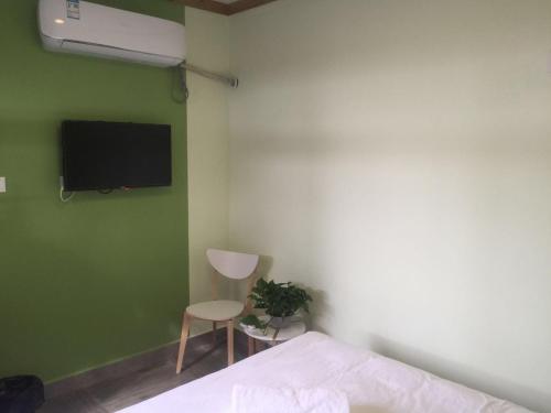 a bedroom with a bed and a tv and a chair at Chez Ina & Jasee in Miyun