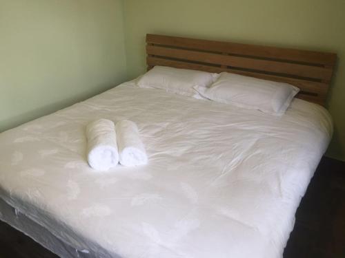 a white bed with two rolled up towels on it at Chez Ina & Jasee in Miyun