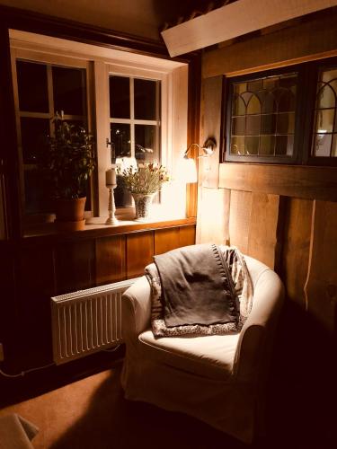 a room with a chair with a blanket on it at Rättviksgårdens Vandrarhem in Rättvik